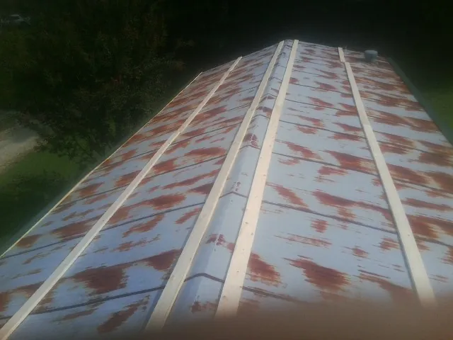 Rusted metal roof panels with new wood purlins before replacement — Storm Damage Roof Repair in Checotah by Roofing Brothers