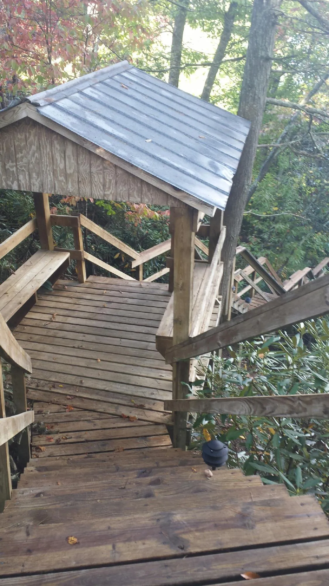 Metal roofed shelter over wooden steps on a wooded walkway — Skylight Repair & Installation work by our crew in Checotah